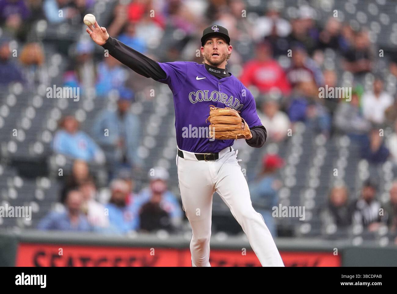 Colorado Rockies third baseman Ryan McMahon throws to first base to put ...