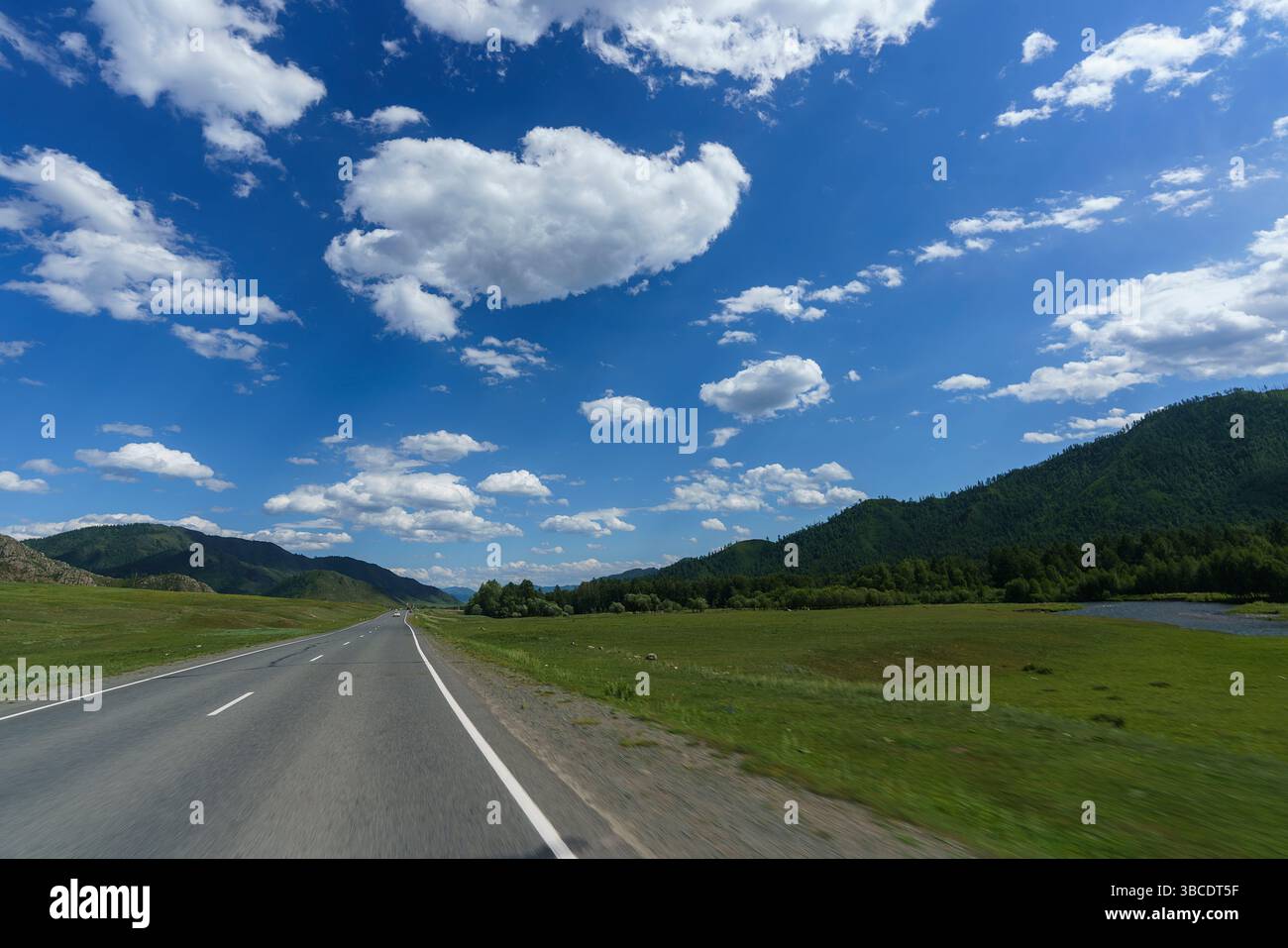 a feelings of speed due to smeared roadsides and nature when driving fast on a highway with a blue sky Stock Photo