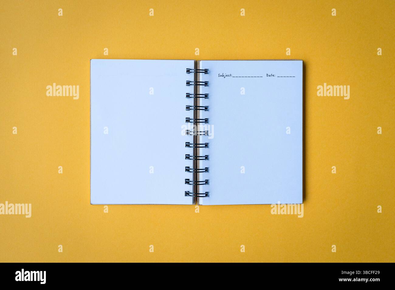 Open notepad, top view. Isolated on yellow background. Stock Photo