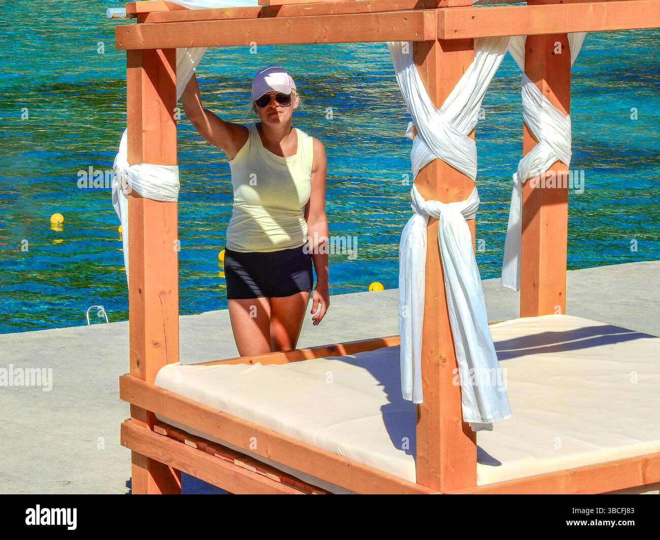 A woman in a hat with a dasaldachim on the seashore on a mattress Stock Photo
