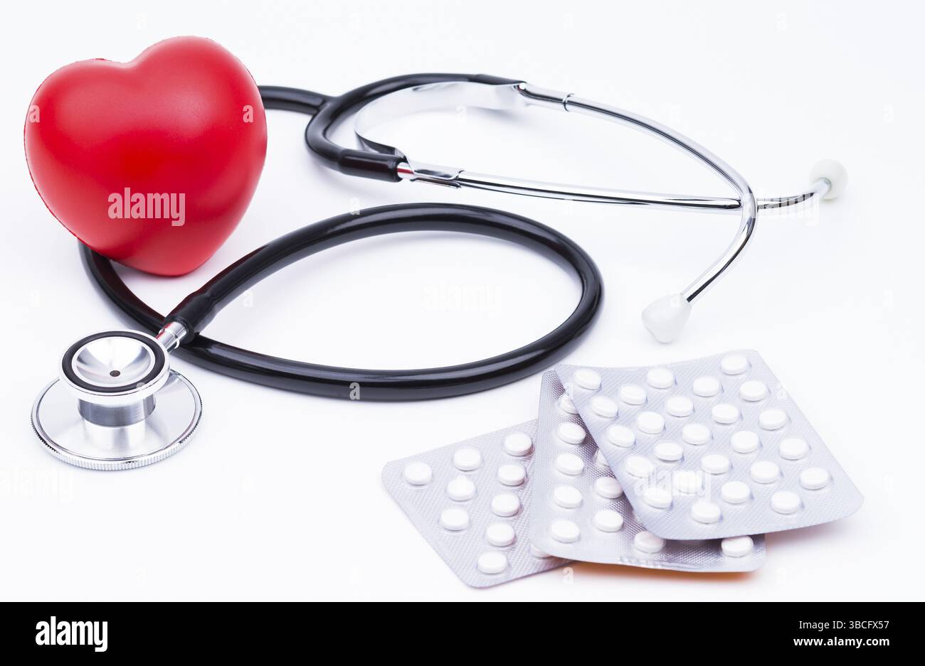 The photo shows a red heart with a stethoscope and tablets against a ...