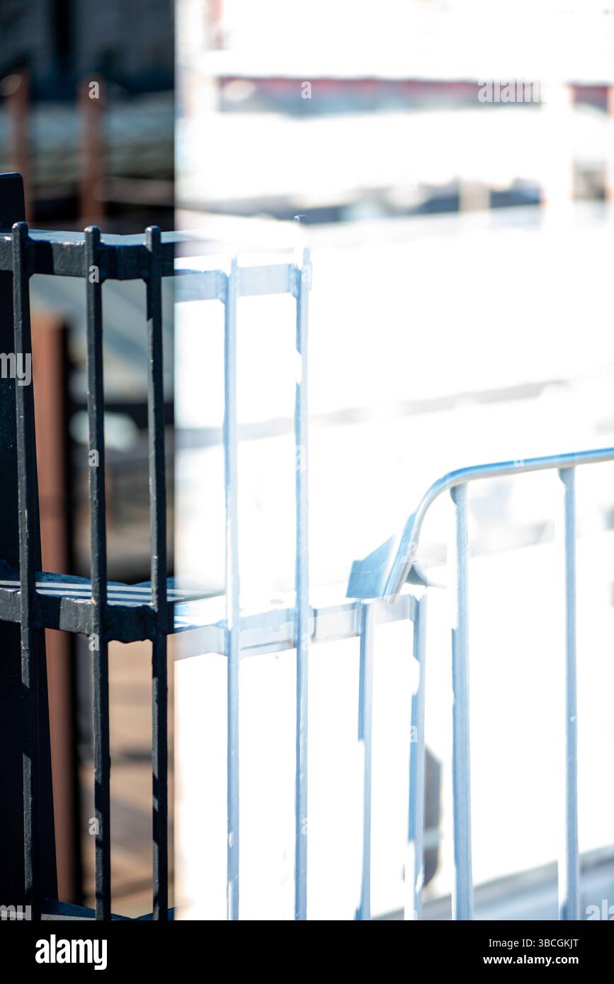 A realistic and moody photo capturing a train station partially obscured by iron or steel fences. Stock Photo
