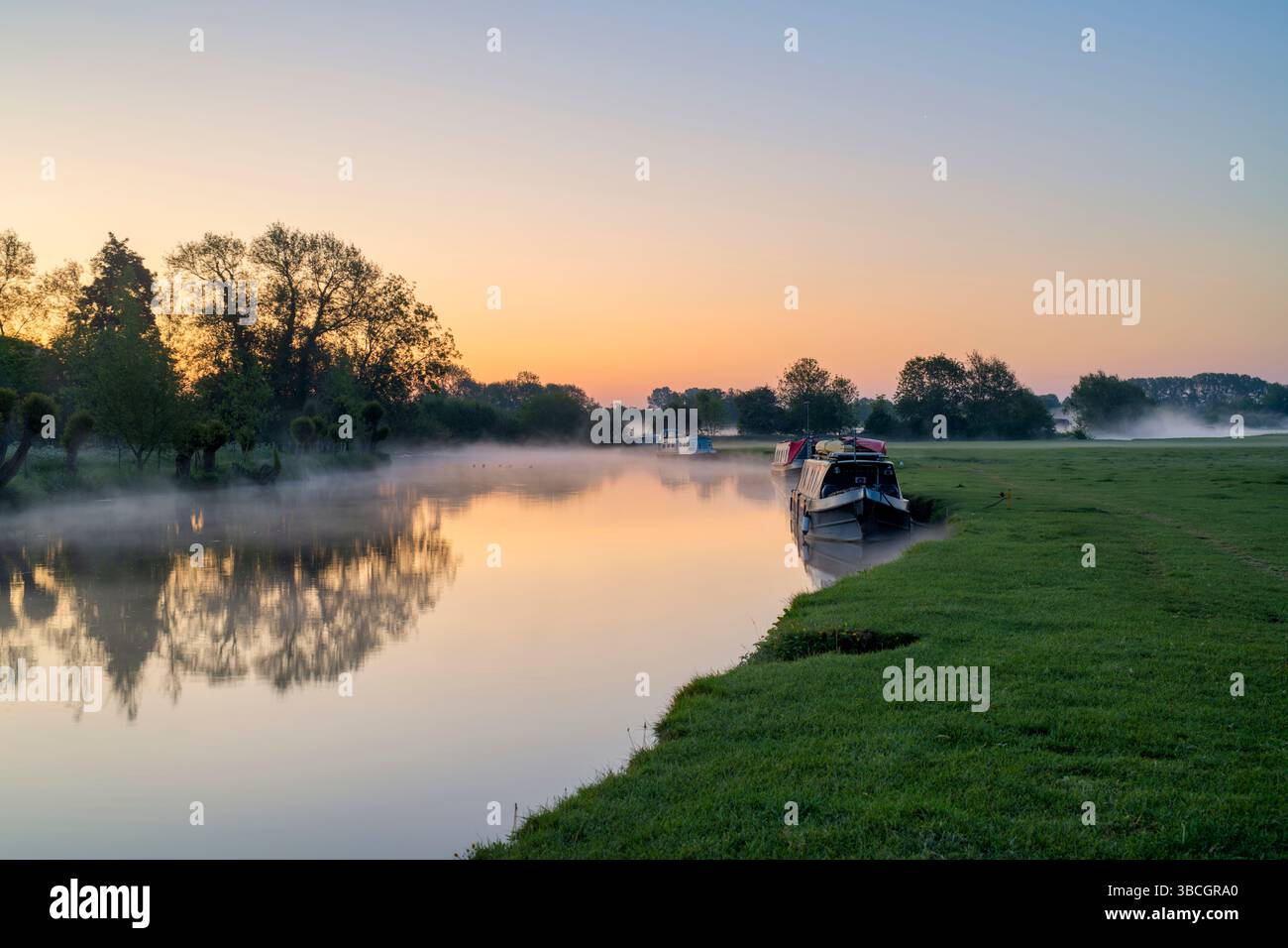 Narrowboats on the river thames at dawn in the spring mist. Lechlade on Thames, Cotswolds, Gloucestershire, England Stock Photo