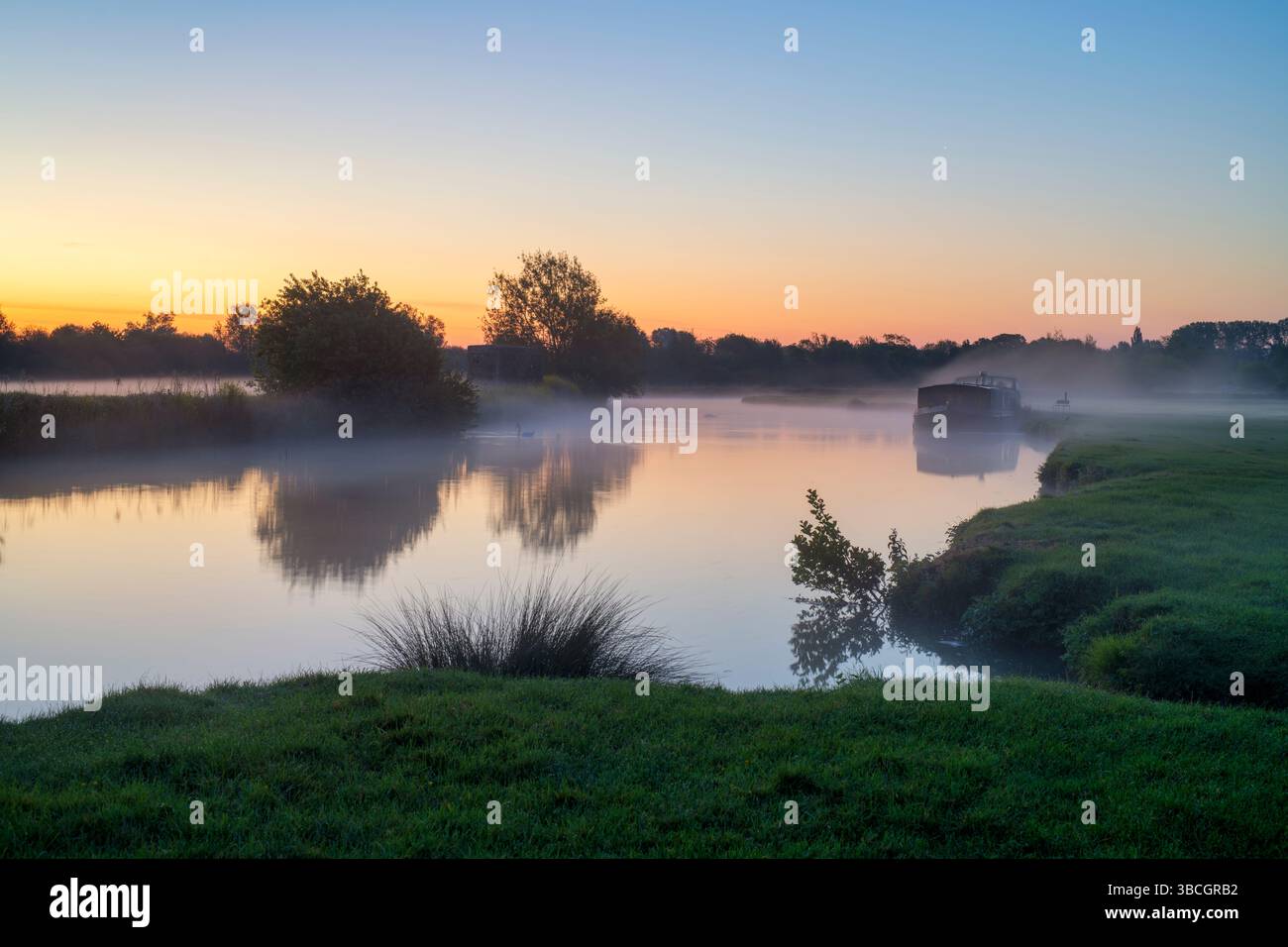 Barge on the river thames at dawn in the spring mist. Lechlade on Thames, Cotswolds, Gloucestershire, England Stock Photo