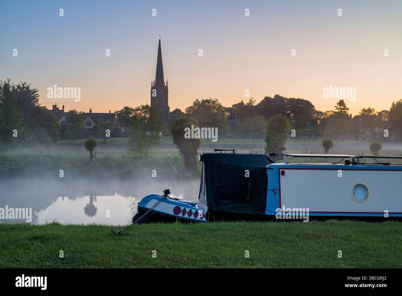 Narrowboat on the river thames at dawn in the spring mist. Lechlade on Thames, Cotswolds, Gloucestershire, England Stock Photo