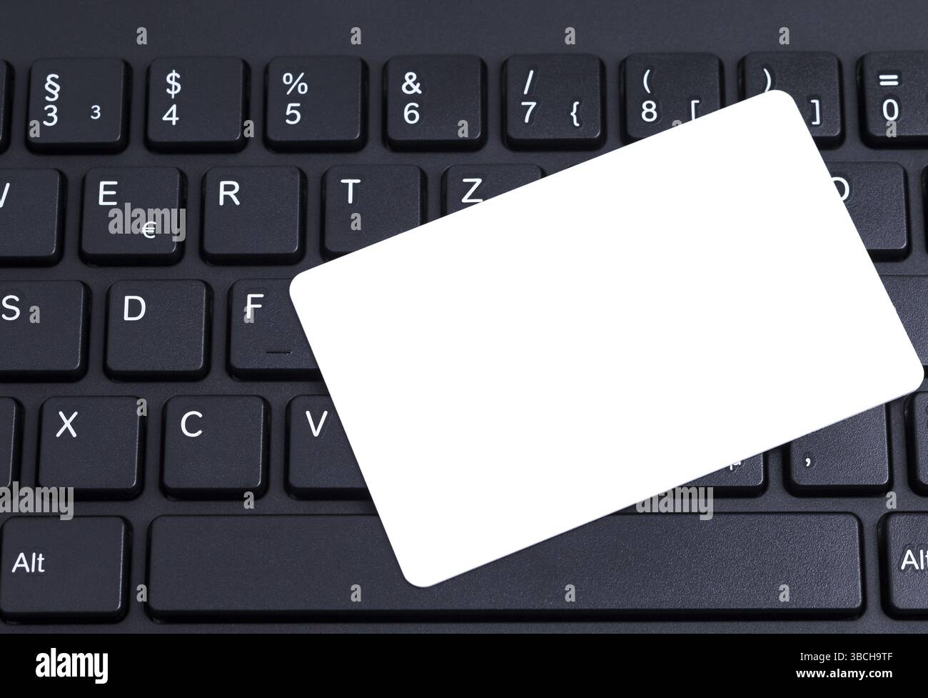 Black keyboard with a blank white pastiche card Stock Photo