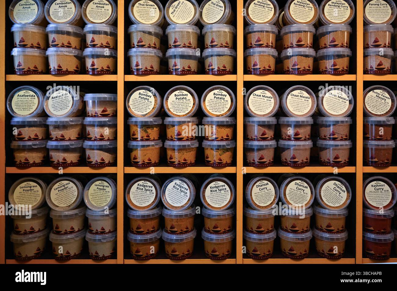 LONDON, UK - MAY 17, 2025:  Rack with tubs of Spice Mountain spice on a delicatessen stall at a food market with label Stock Photo