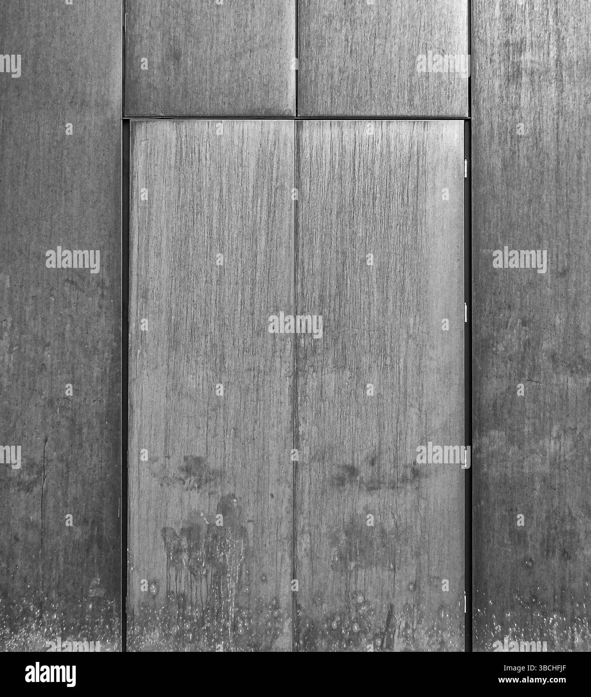 Grey brushed steel door set in a metal wall Stock Photo