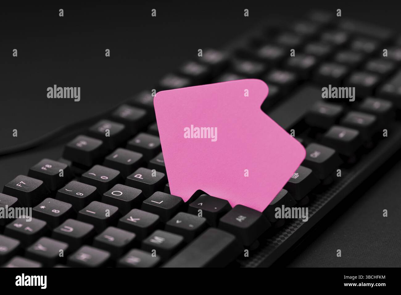 Sticker lying on black keyboard. Important message written over paper Stock Photo