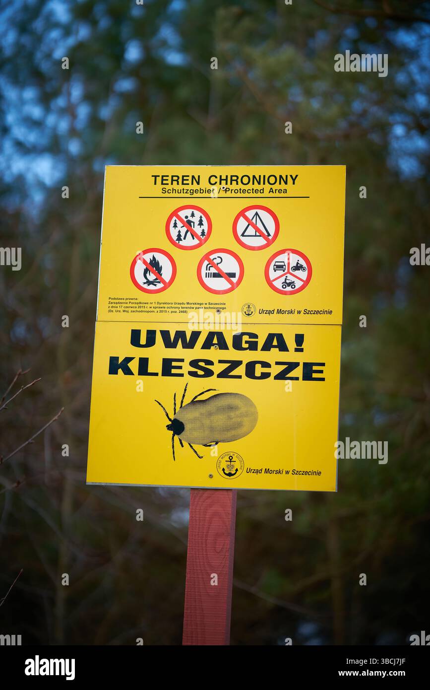 Sign on the Polish Baltic coast with the inscription Uwaga Kleszcze. Translation: attention ticks Stock Photo