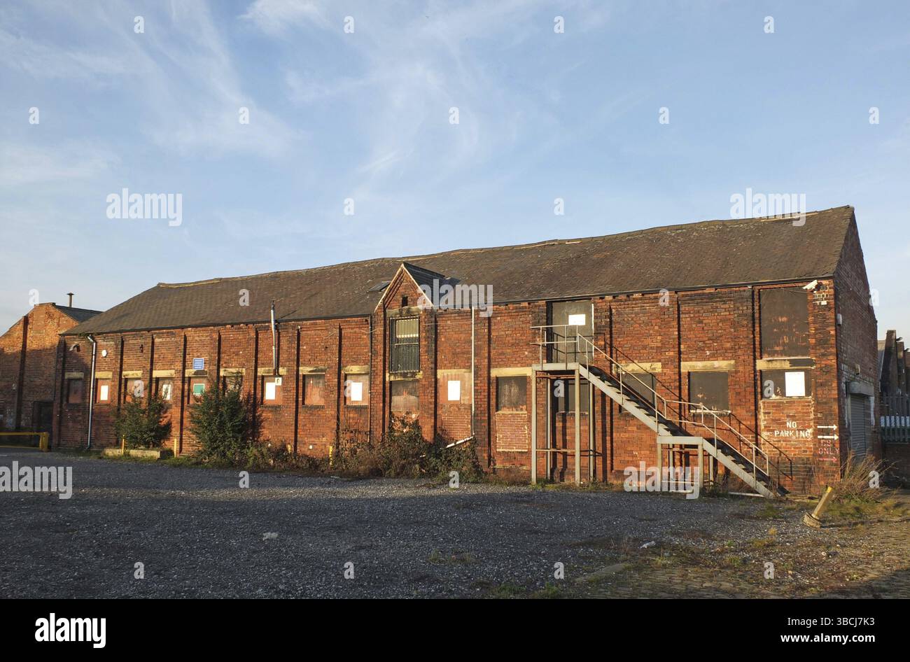 An old abandoned brick factory building with boarded up windows and ...