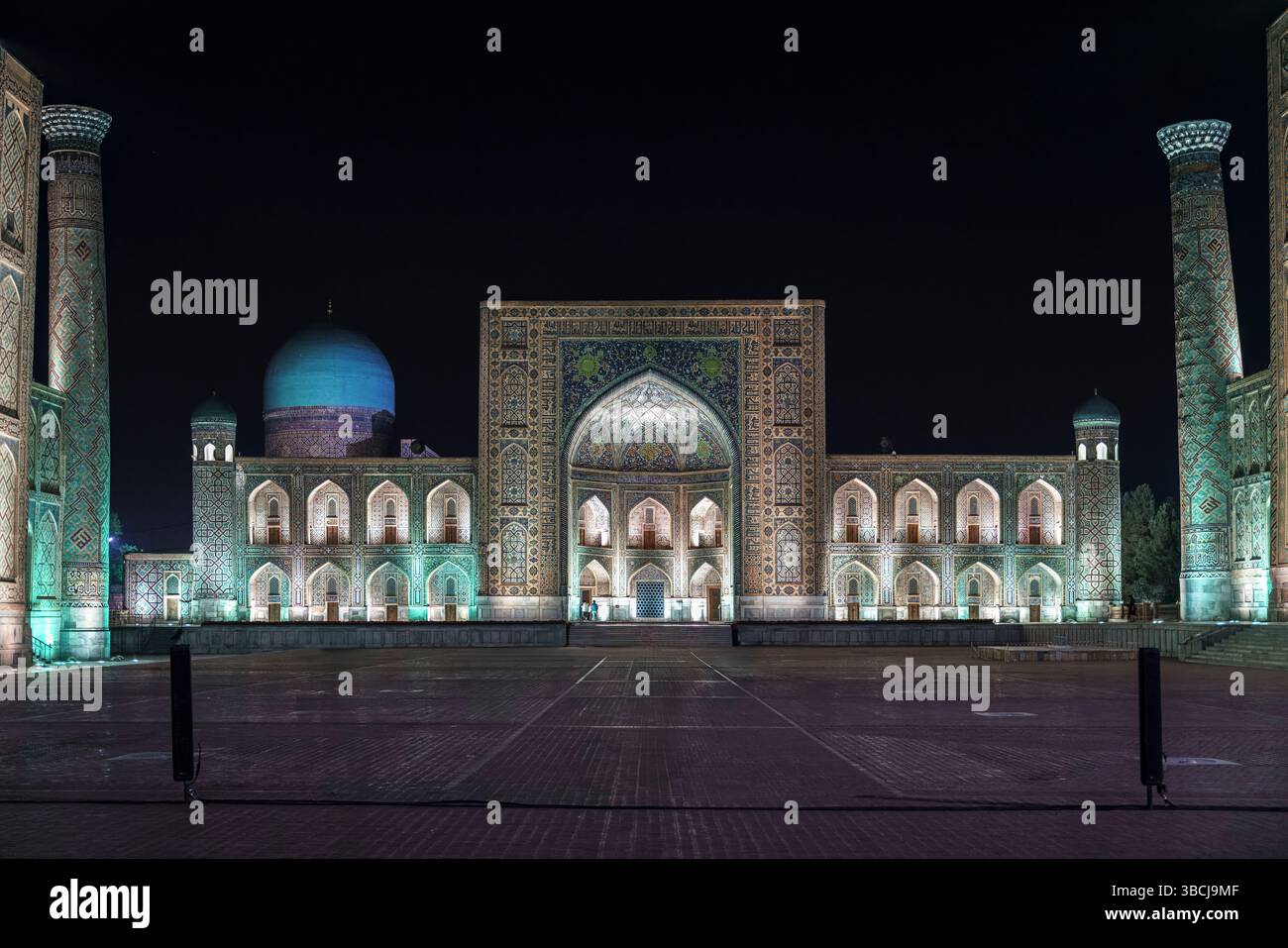 The front view of Tilya Kori Madrasa is dramatically lit, emphasizing ...