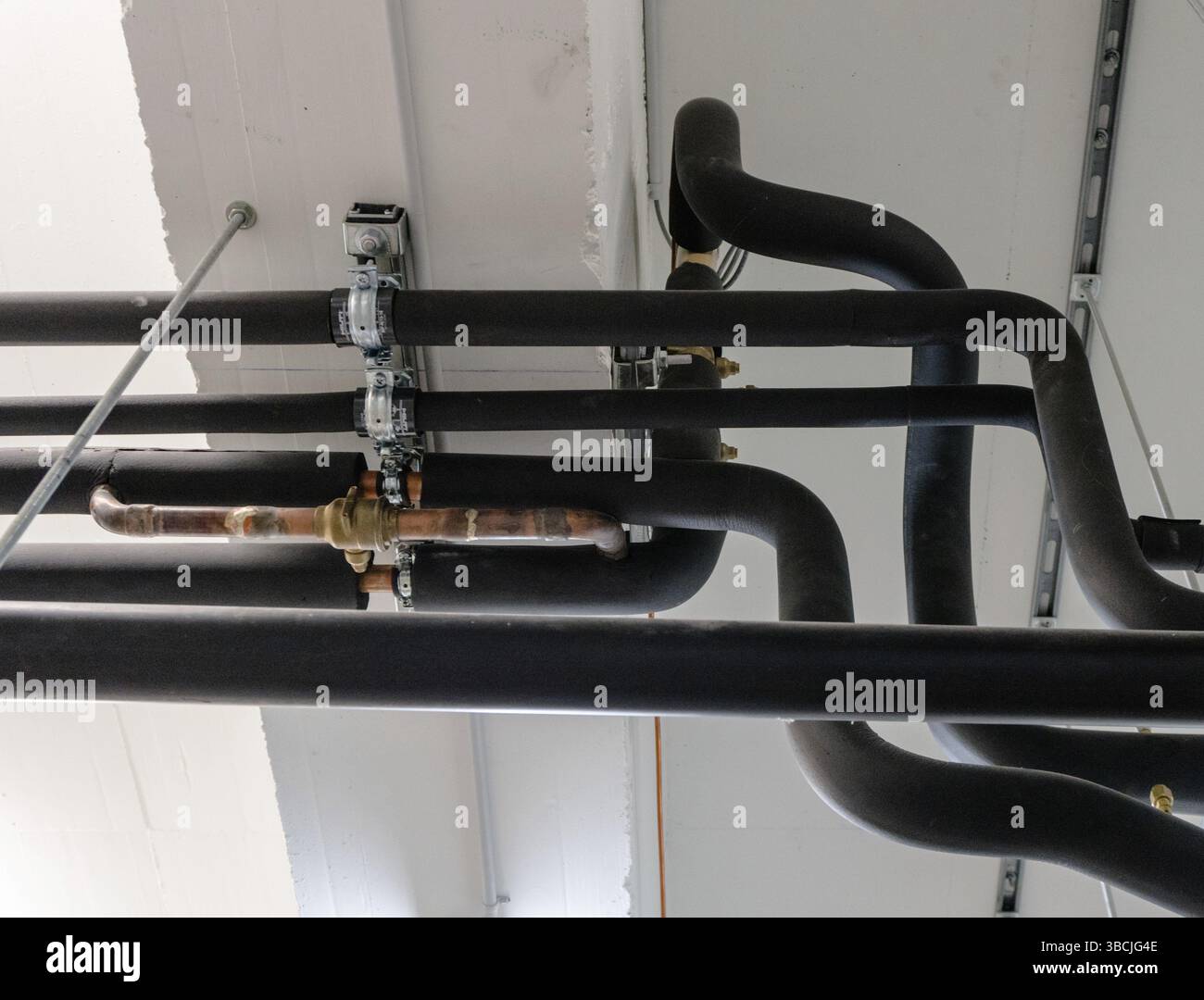 Image showcasing metal and plastic pipe system on the cellar ceiling of an apartment ...