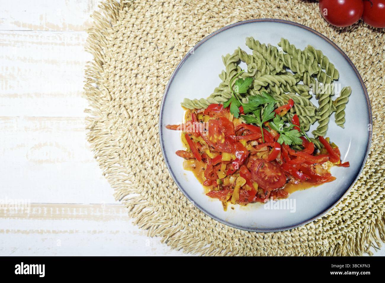 Green legume noodles made from mung beans and vegetable ragout from peppers and tomatoes, vegan gluten-free meal with lots of protein, vitamins and vi Stock Photo