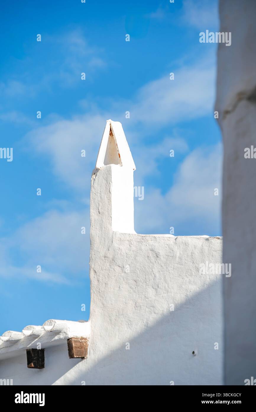 Close-up view of a pristine whitewashed chimney, characteristic of traditional Mediterranean architecture. The clean lines and white texture embody th Stock Photo