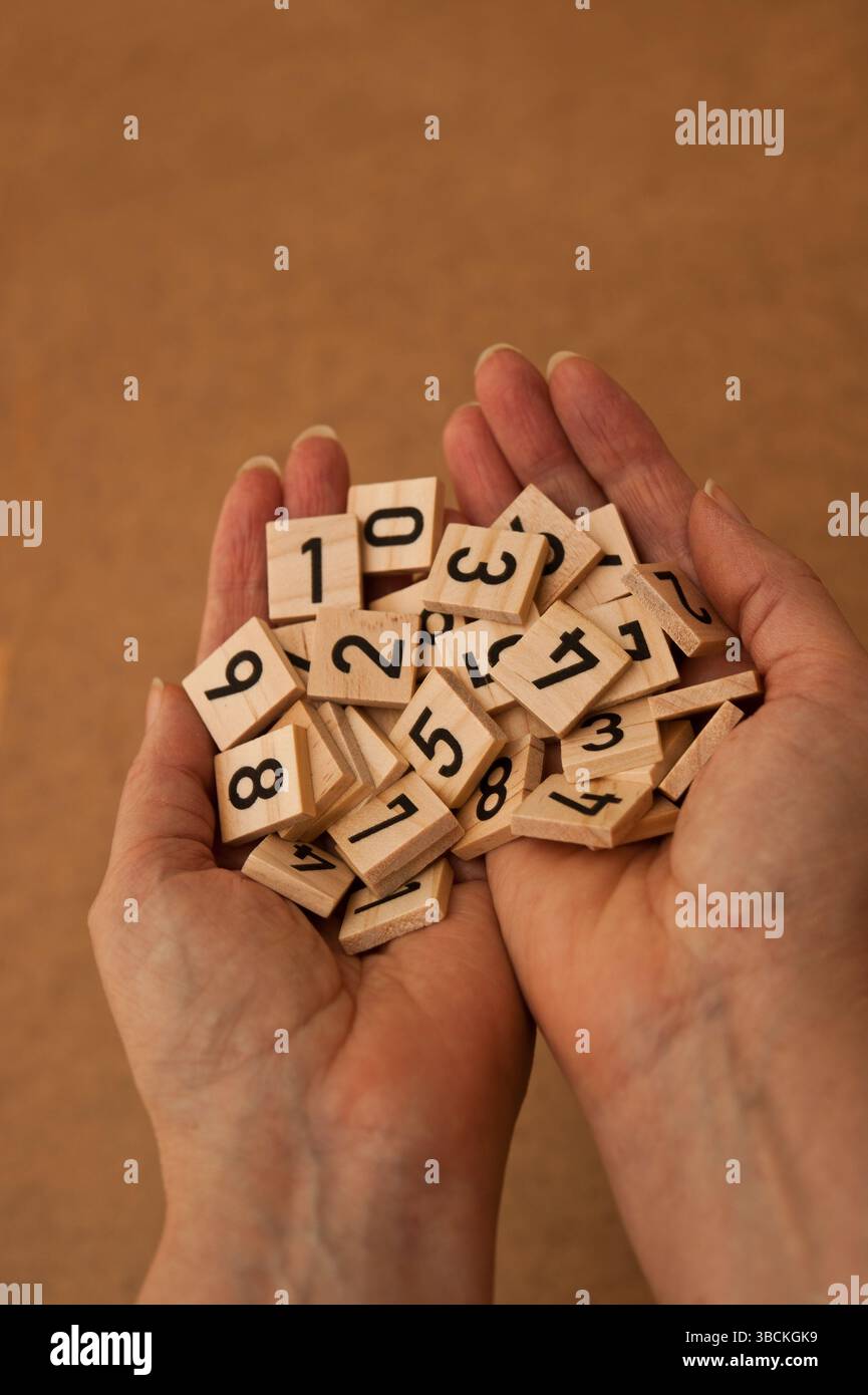 woman holding numbers tiles in her hands Stock Photo