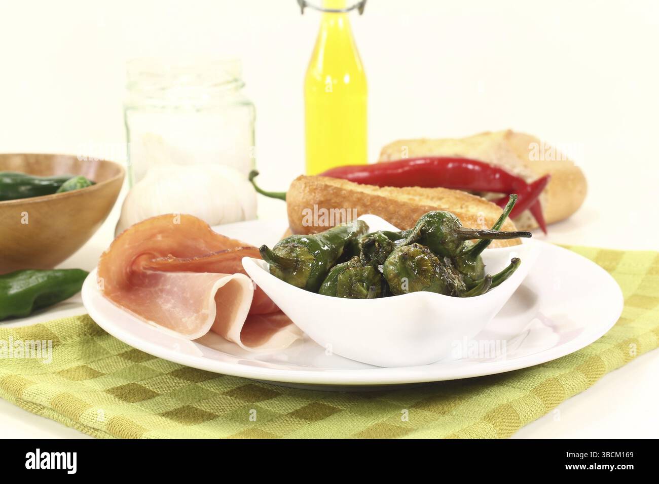 Pimientos with salt, Serrano ham and fried baguette Stock Photo