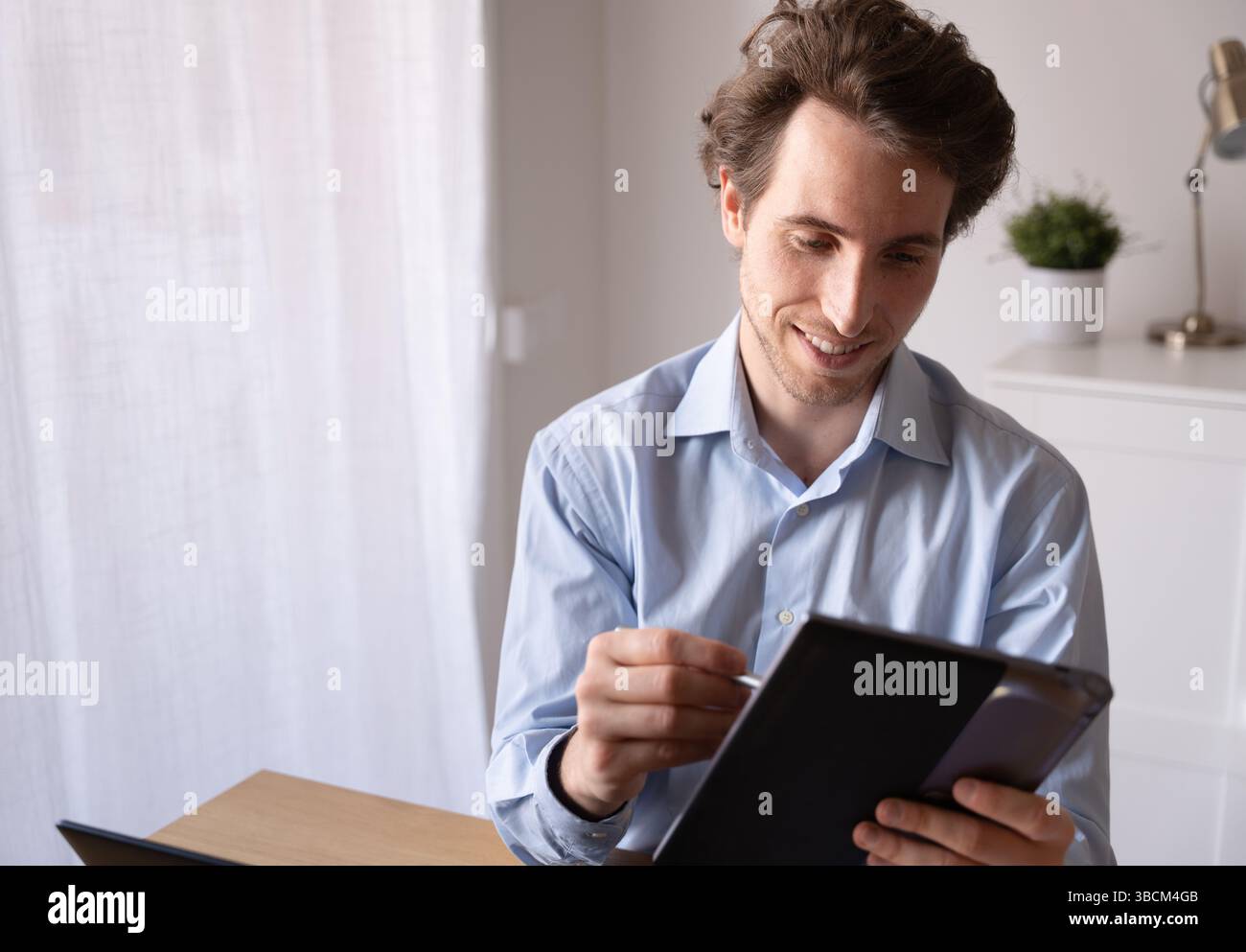 Remote work scene with businessman using technology and managing his time Stock Photo