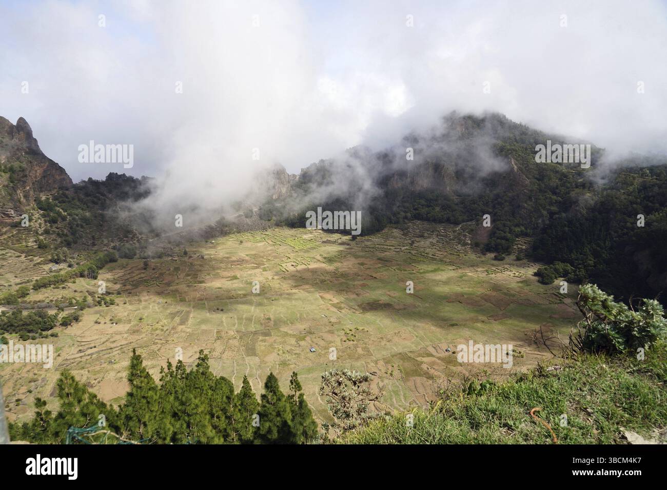 View into the crater Cova de Paul, caldera, rising trade wind clouds ...