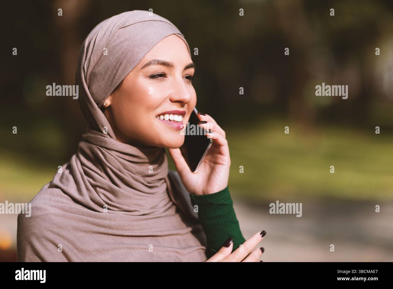 Happy Islamic Woman In Hijab Talking On Mobile Phone Outside Stock ...