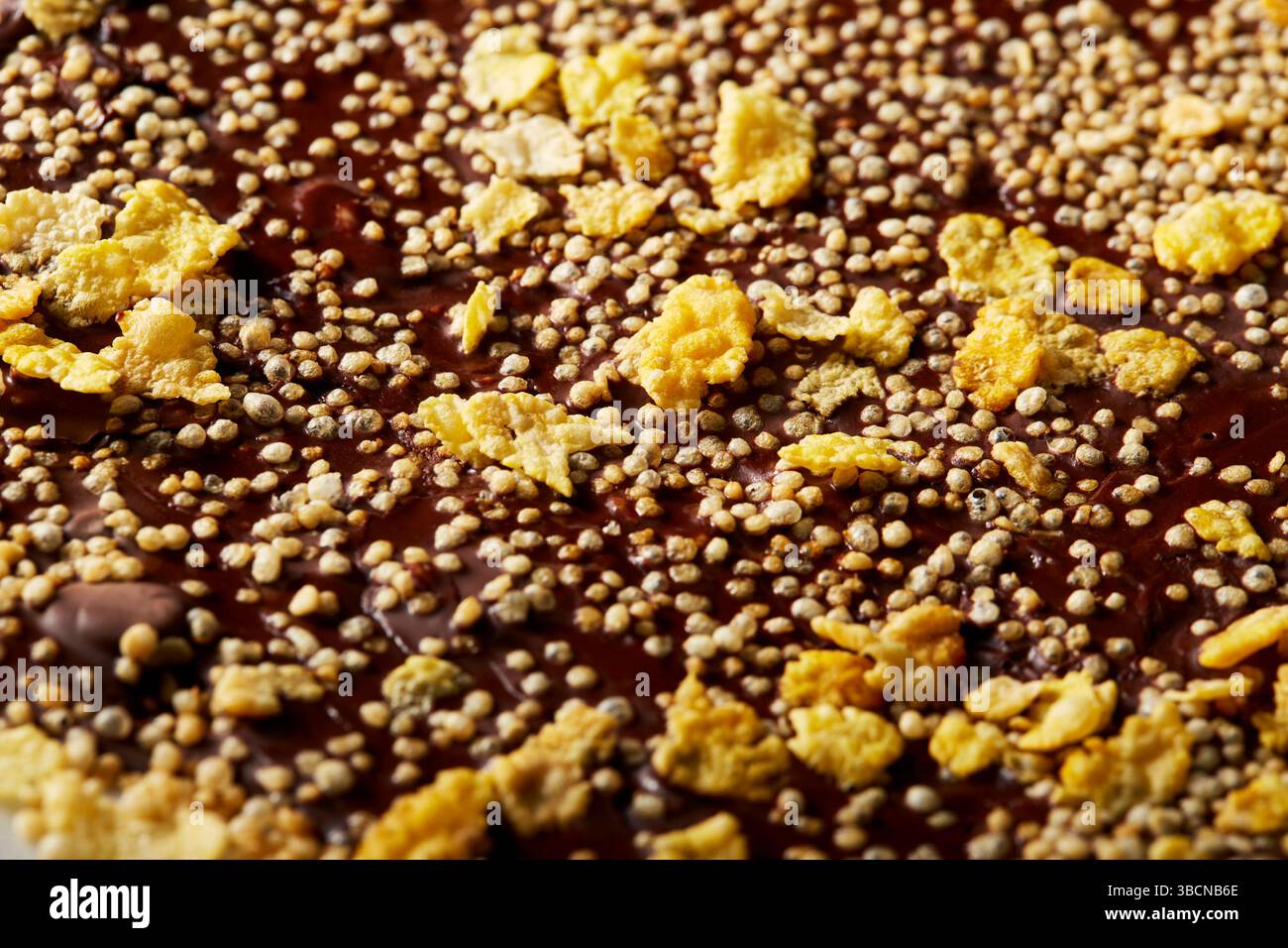 Chocolate bark with puffed quinoa and cornflakes on parchment Stock Photo