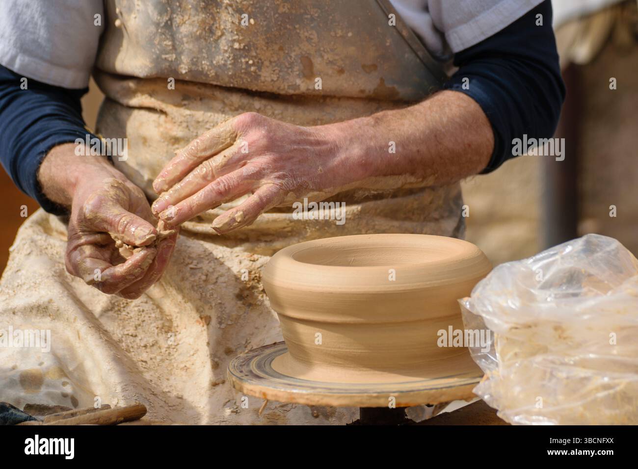 detail of traditional pottery making process, artist preparing material ...
