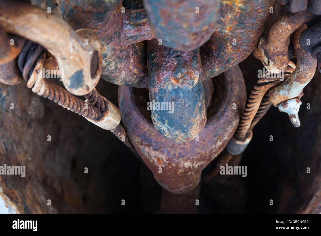 Rusty anchor chain on a ship in an anchor hawsepipe close-up. Stock Photo