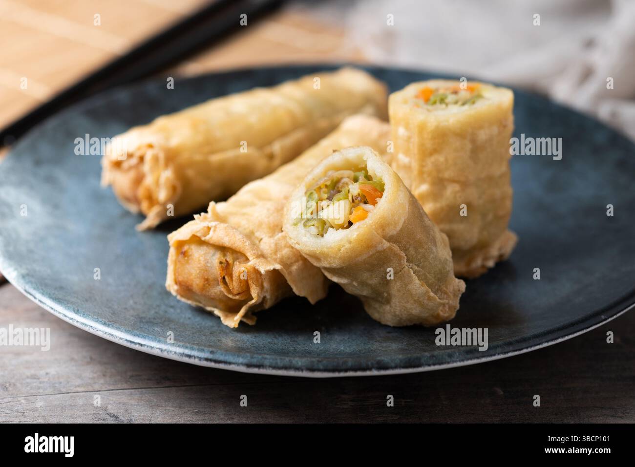 Crispy Spring Rolls on Ceramic Plate on wooden table Stock Photo
