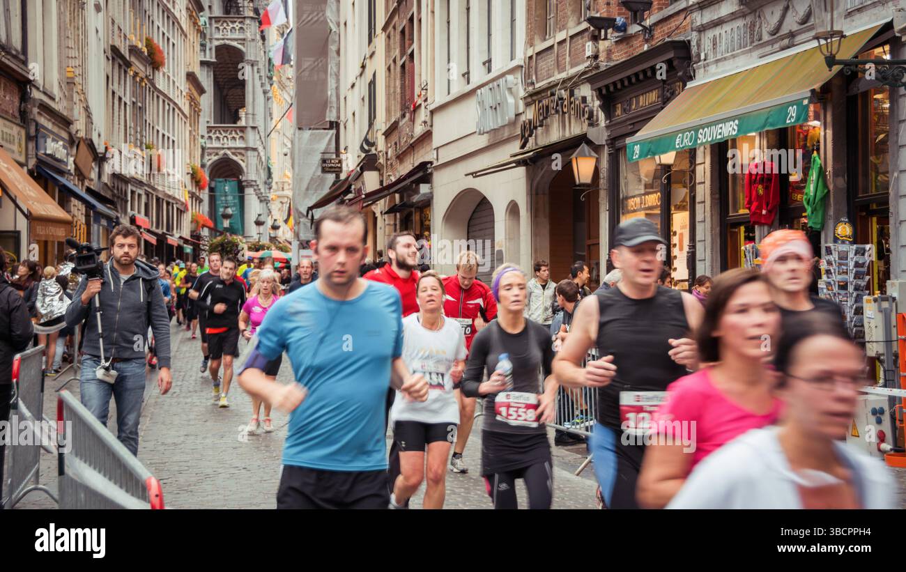 Belfius Brussels Marathon 2014: lots of people running in narrows streets of belgian capital's old town. Stock Photo
