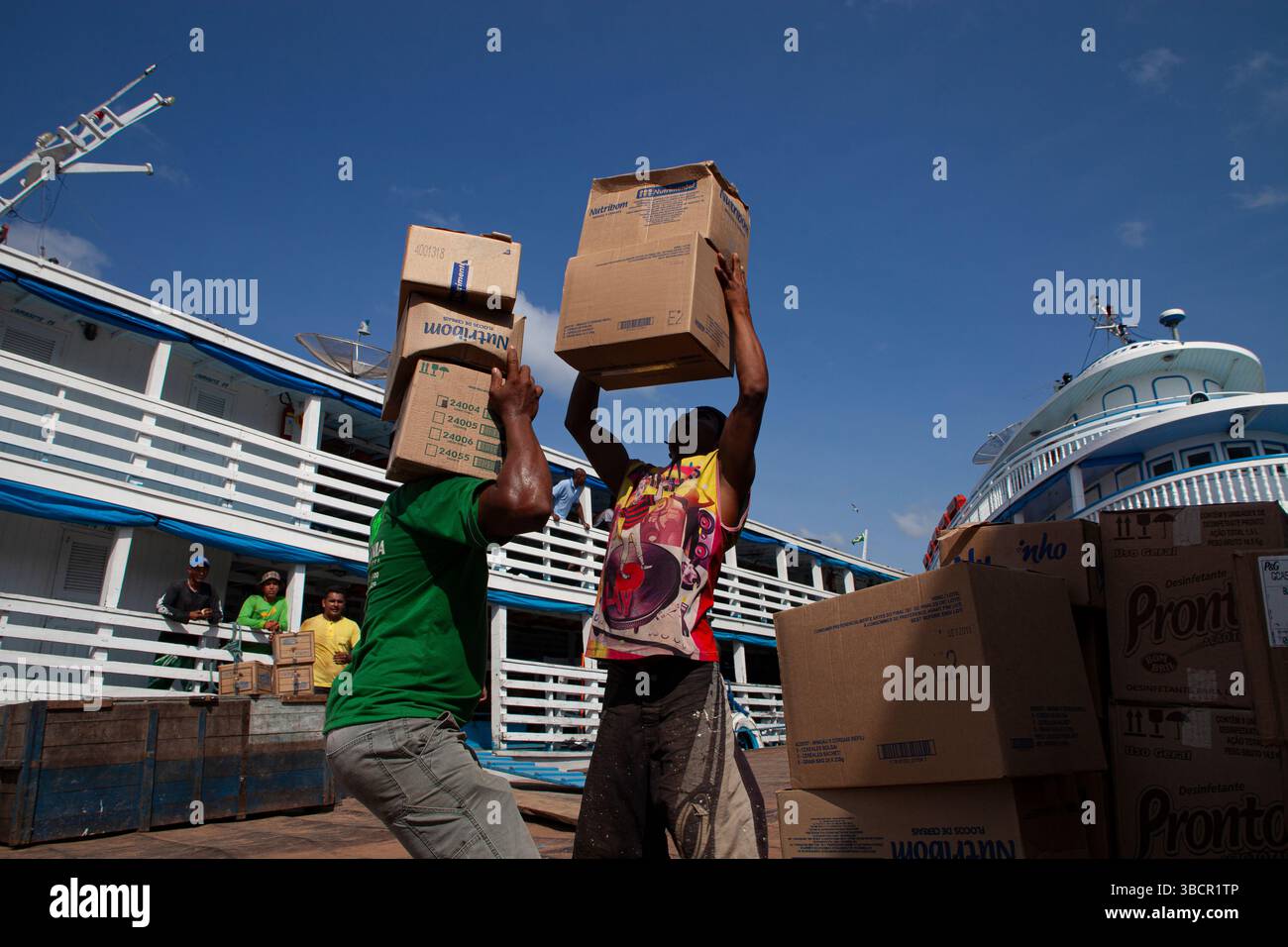 Dockworkers load diverse merchandise onto traditional Amazon riverboats at the Port of Santarém in Pará, Brazil. Stock Photo