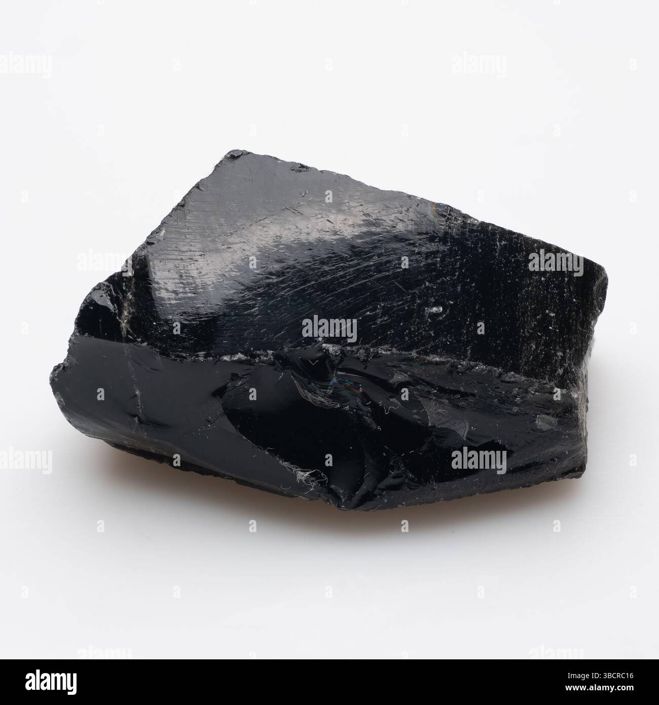 A raw, dark, glossy obsidian specimen featuring a rough, fractured ...