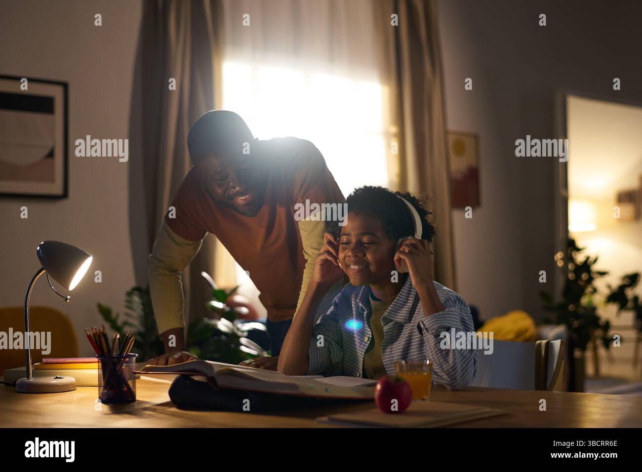 Enjoying Study Session with Family Helping in Evening Stock Photo