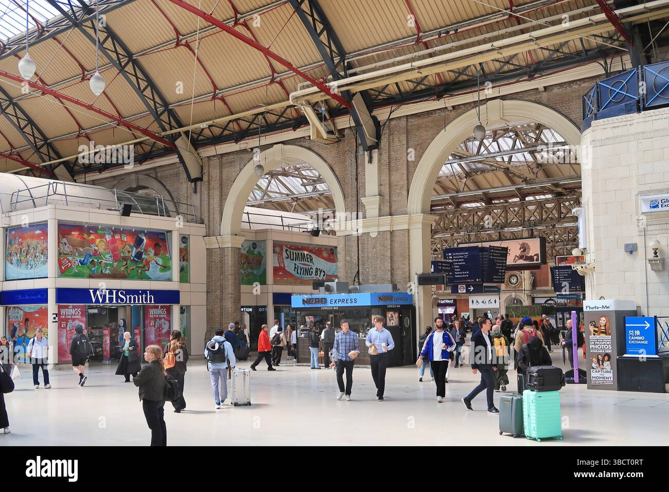 Main passenger concourse at London's busy Victoria Station. Shows passengers and commuters. Stock Photo