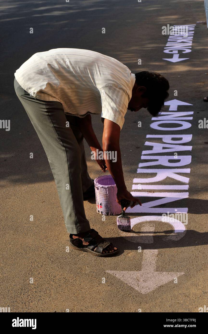 Inde du Sud,Tamil Nadu,Pondicherry,homme peignant sur le trottoir une inscription "no Parking"/ Indian man painting inscription on asphalt in Puducher Stock Photo