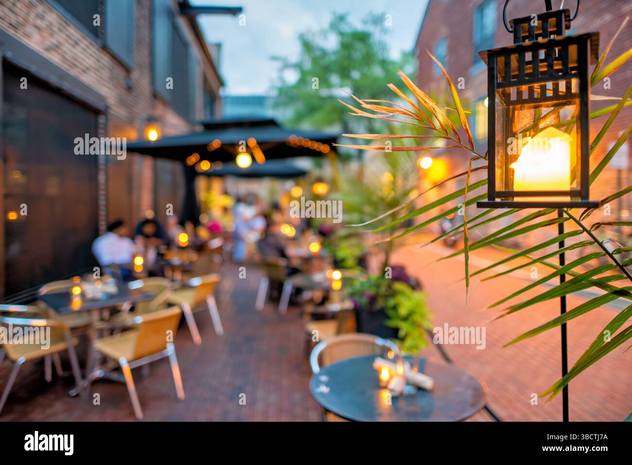 Virtue Feed And Grain Restaurant Outdoor Seating Alexandria Virginia // ALEXANDRIA, Virginia — Outdoor seating at Virtue Feed and Grain restaurant in the historic district of Old Town Alexandria. The restaurant, housed in a renovated 19th-century warehouse that once served as a feed and grain store, offers alfresco dining options for patrons. Located just a block from the Potomac River waterfront at 106 South Union Street, the outdoor space allows diners to enjoy meals while experiencing the historic charm of Old Town Alexandria. Stock Photo