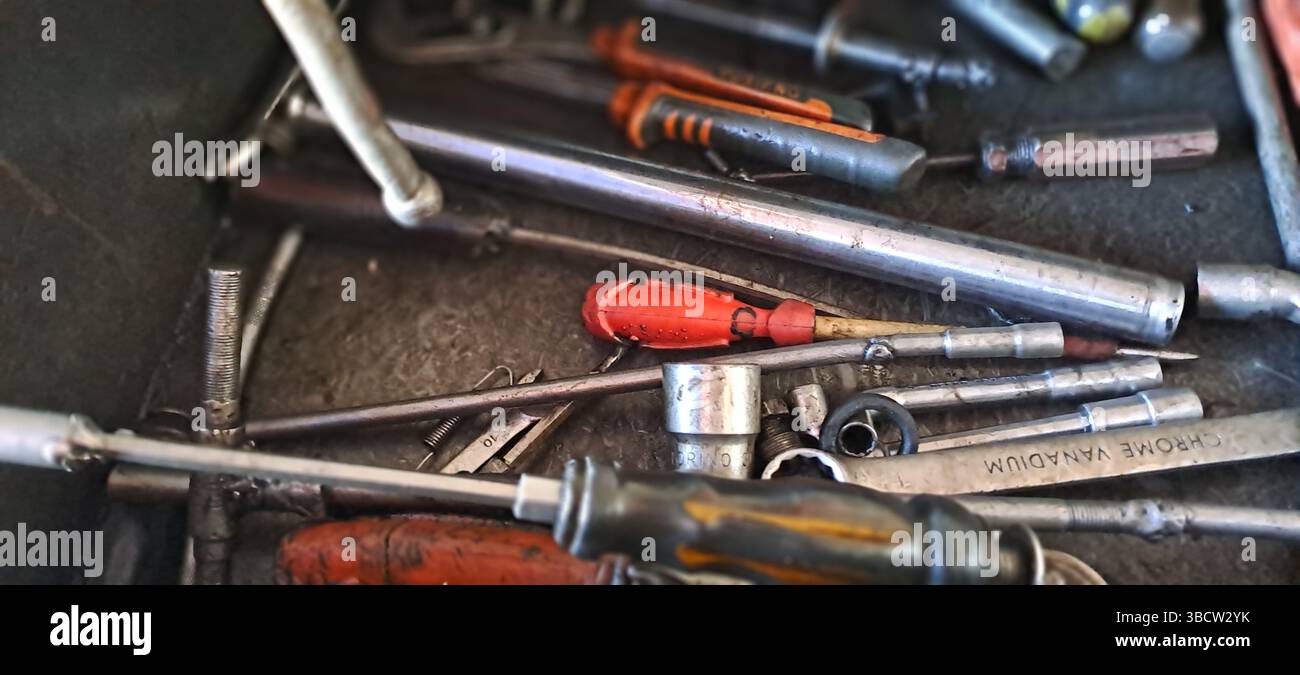 Chrome vanadium tools and various other tools laying messily in metal toolbox Stock Photo
