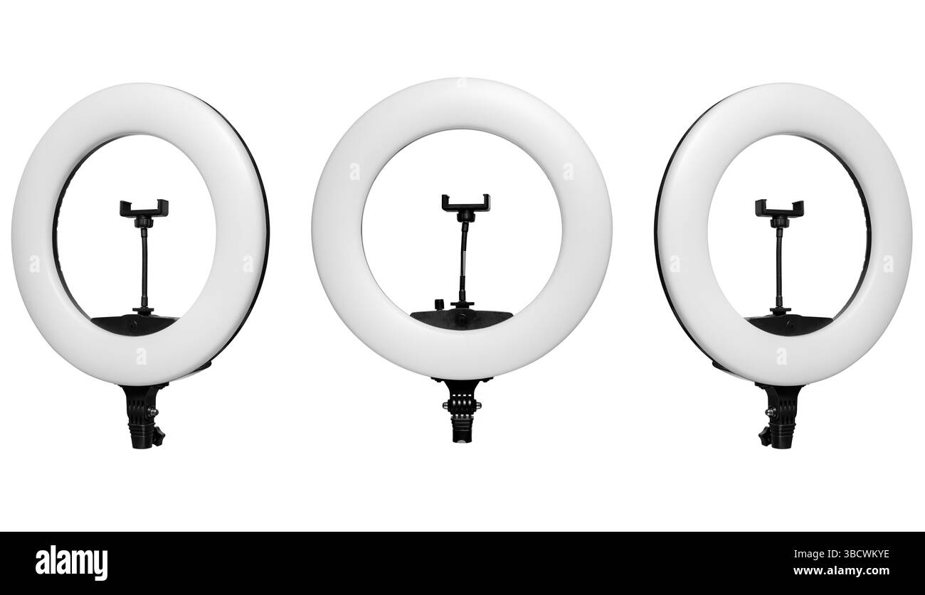 Three LED ring lights with smartphone holders arranged in a row on a white background. Stock Photo
