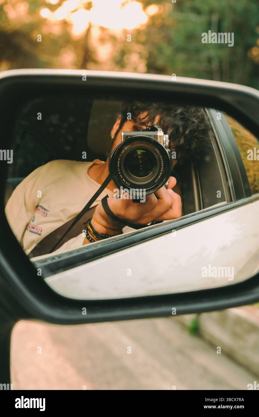 A photographer shooting himself in the car mirror Stock Photo