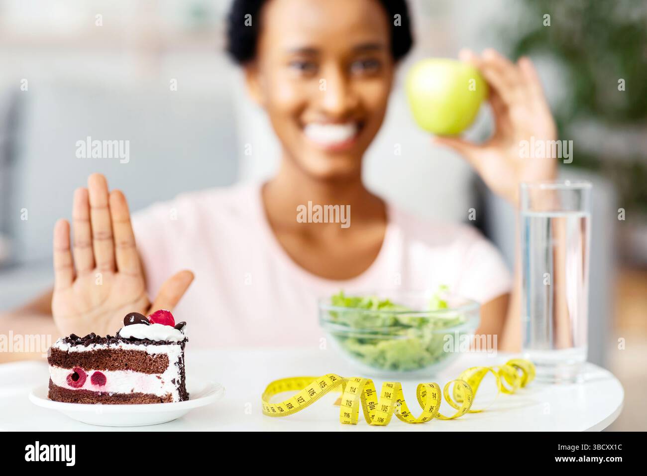 Refusing Dessert Happy black woman choosing fresh apple over unhealthy cake, refusing to ...