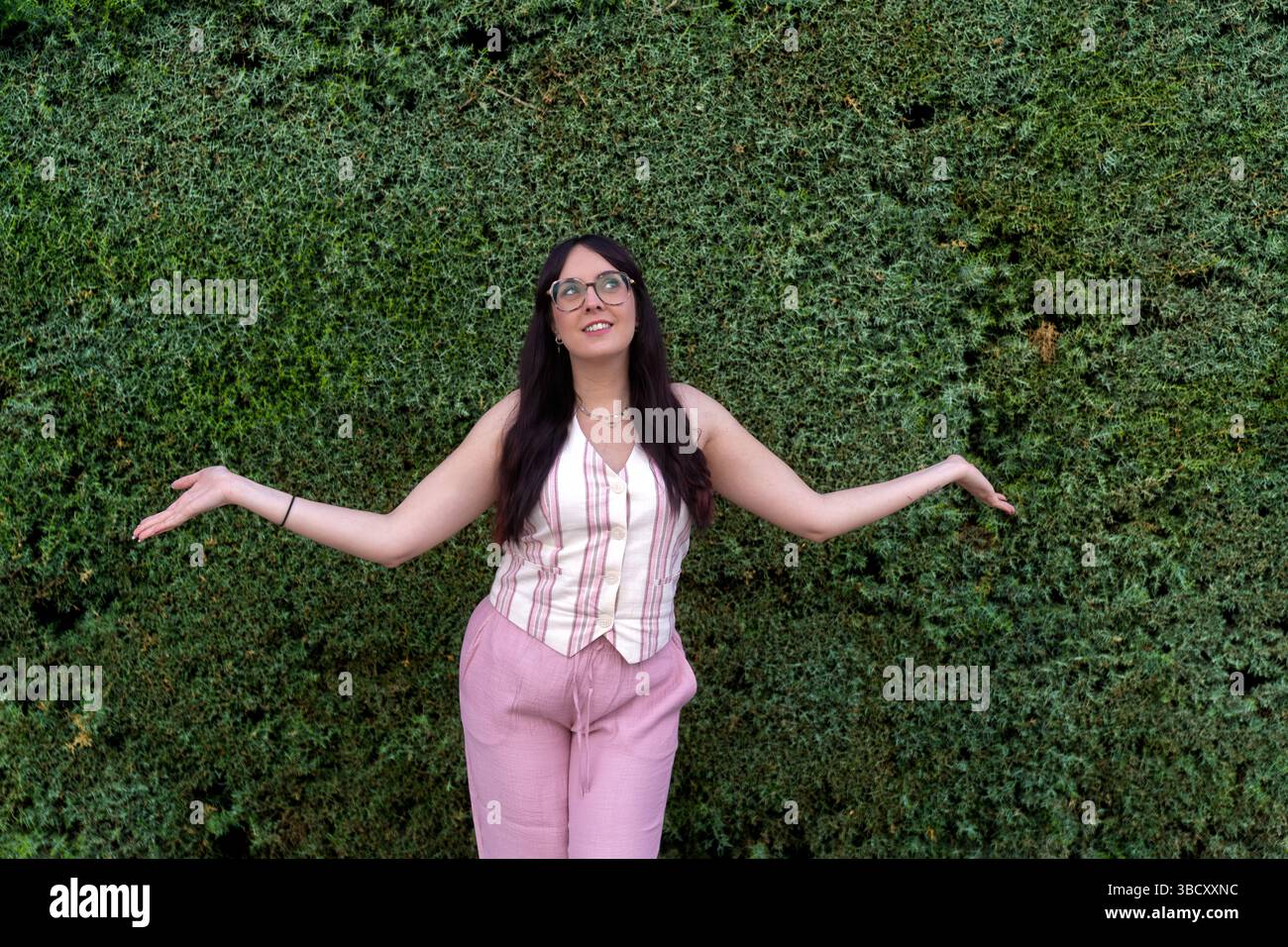 Hedged Opening Young woman opening arms in front of green hedge Stock Photo - Alamy