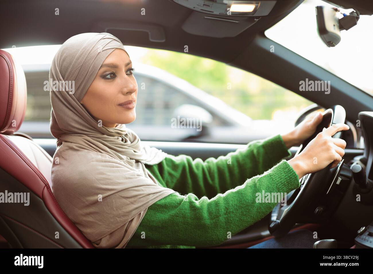 Cheerful muslim woman driving her new car Stock Photo