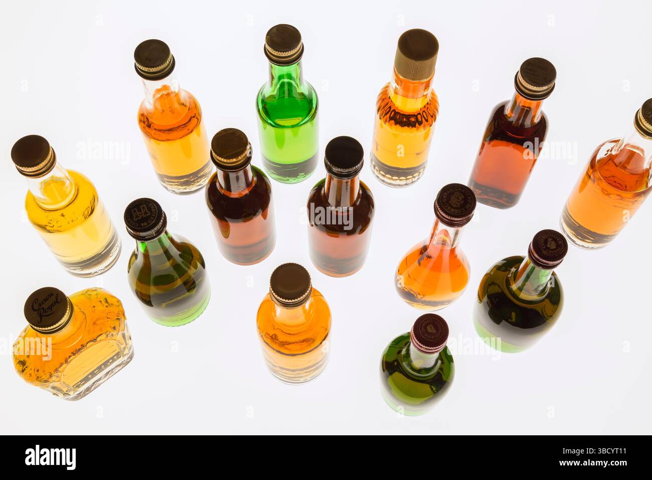 Colourful assorted shaped miniature size liquor bottles on white translucent background. Stock Photo
