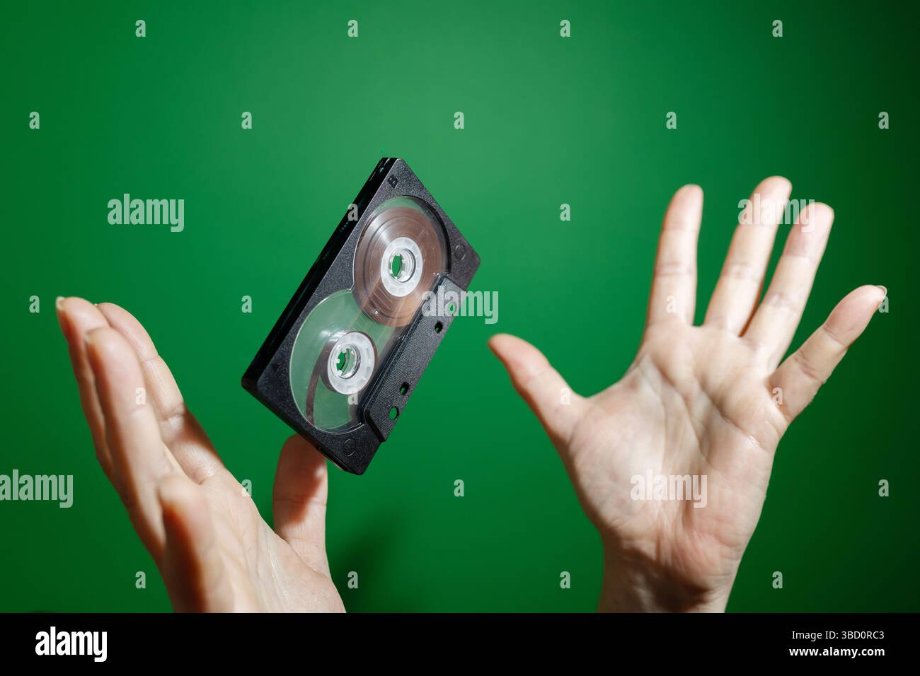 A VHS tape is being tossed high into the air, highlighting the feelings of nostalgia and the charm of retro media Stock Photo