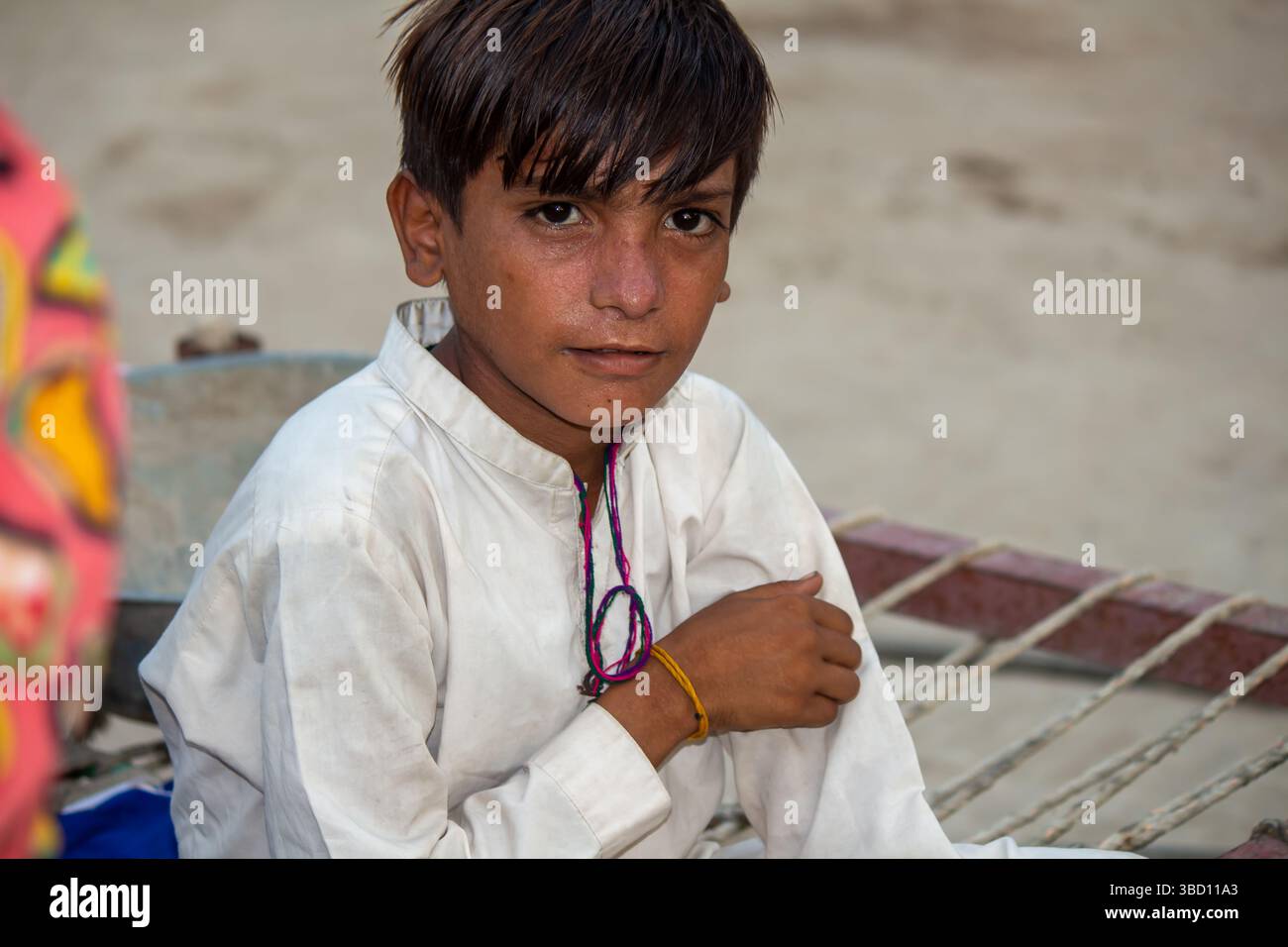 Portrait of a Young Rural Boy in Traditional Dress Sitting Outdoors ...