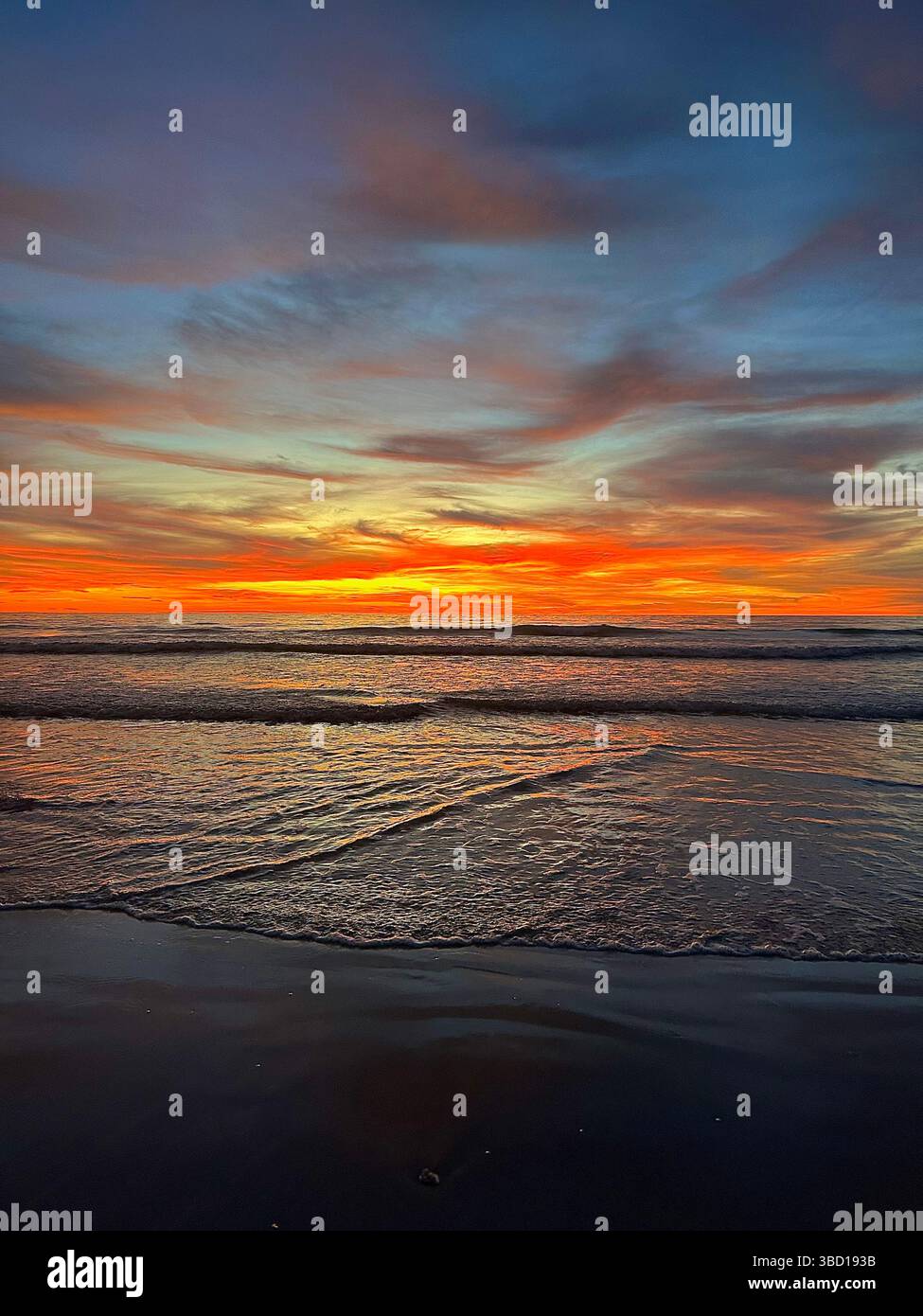 Fiery sunset over gentle waves with vivid reflections and dramatic clouds—perfect for travel, lifestyle, and inspirational content. - Smartphone Captured Stock Image