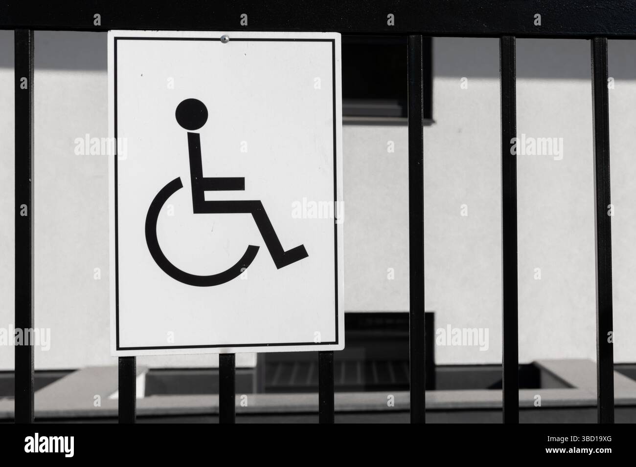 Close-up of a black and white wheelchair accessibility sign attached to ...