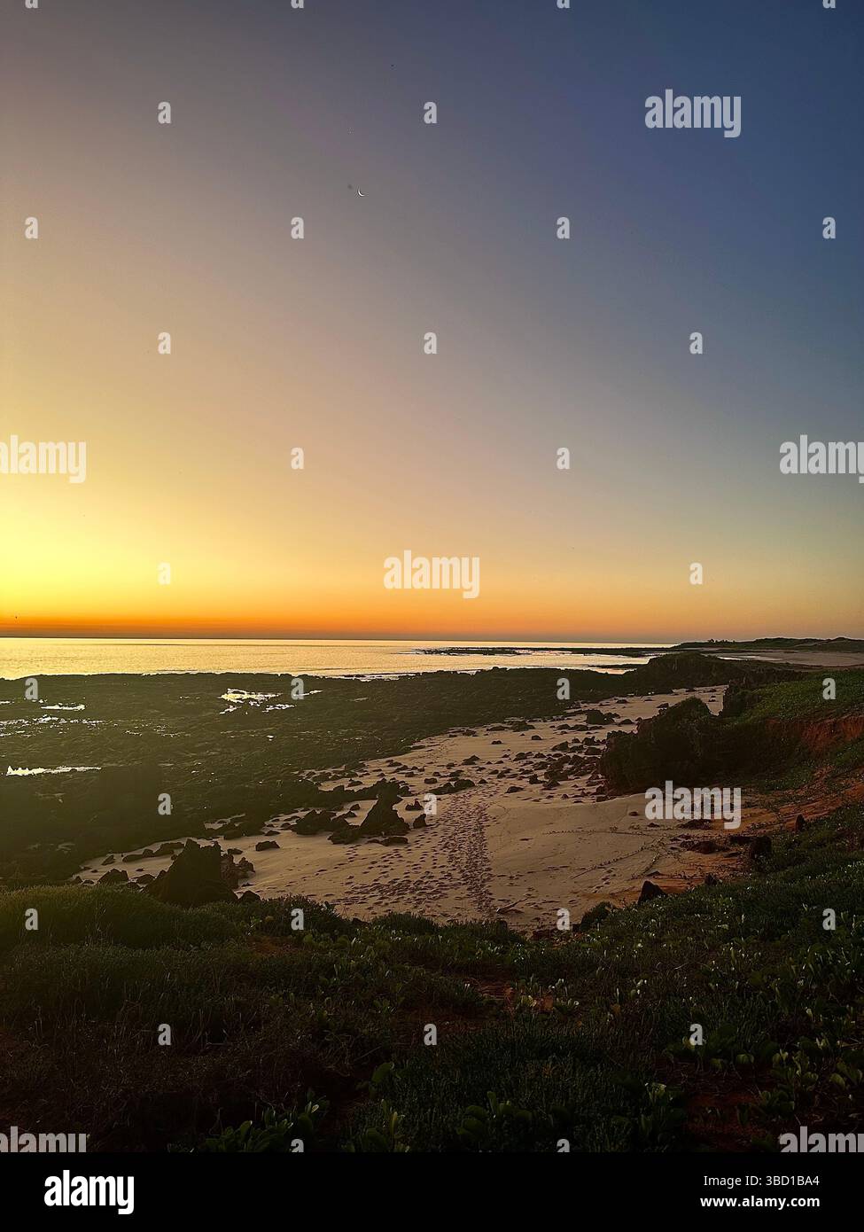 Golden coastal sunrise over rocky shoreline and sandy beach—ideal for travel, nature, wellness, and inspirational outdoor themes. - Smartphone Captured Stock Image