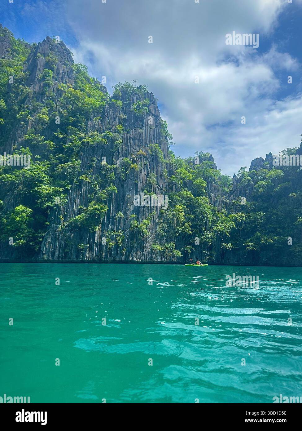 Dramatic limestone cliffs and lush jungle meet clear turquoise waters under a tropical sky—ideal for travel, nature, and eco-tourism themes. - Smartphone Captured Stock Image
