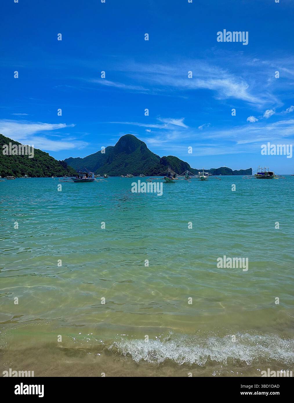 Scenic tropical bay with turquoise waters, green mountains, and boats under a bright blue sky—perfect for travel, nature, and adventure themes. - Smartphone Captured Stock Image