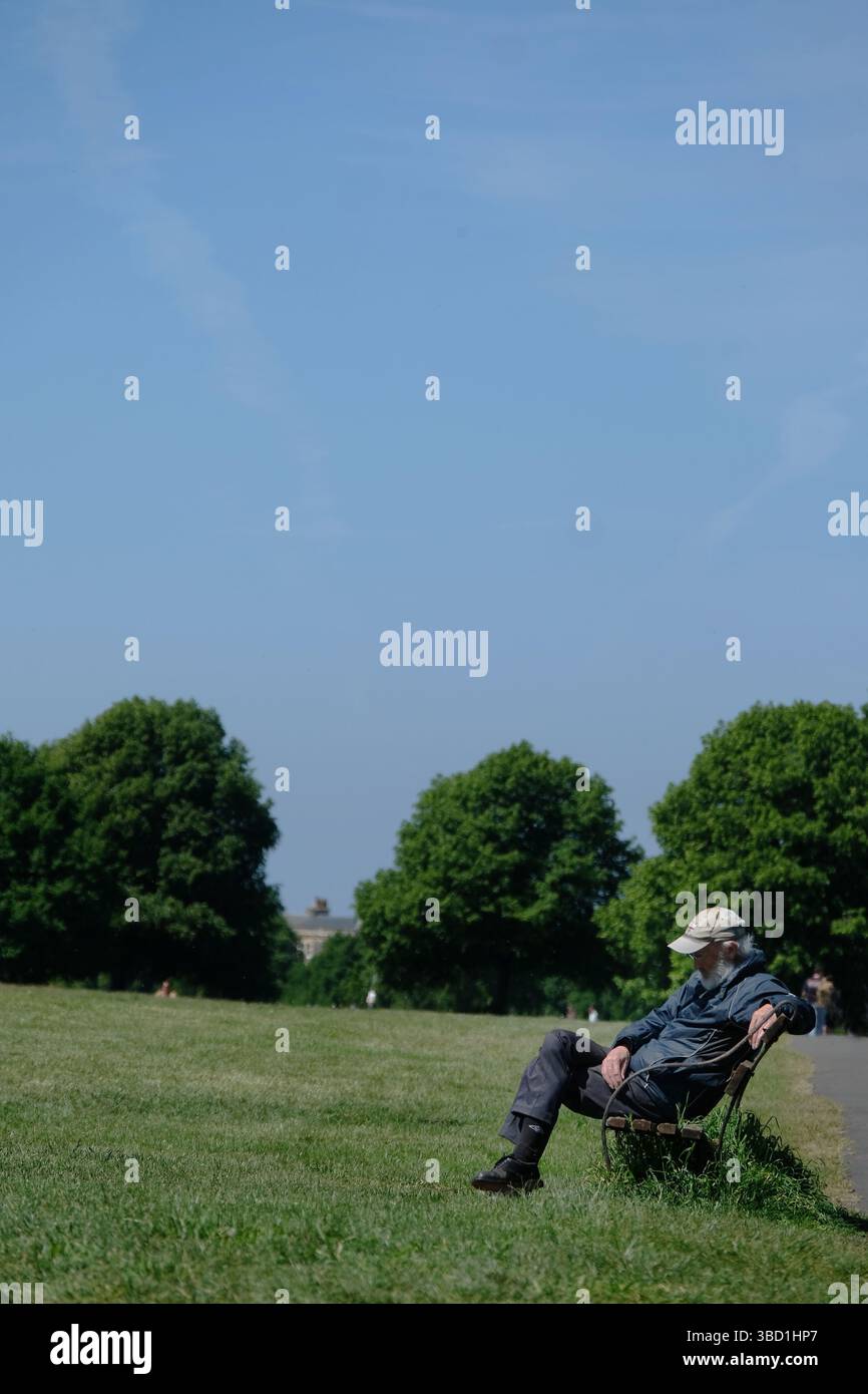 An old man sitting on a bench in the sunshine Stock Photo - Alamy